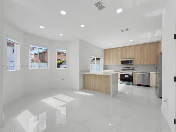a large kitchen with stainless steel appliances lots of counter top space and cabinets