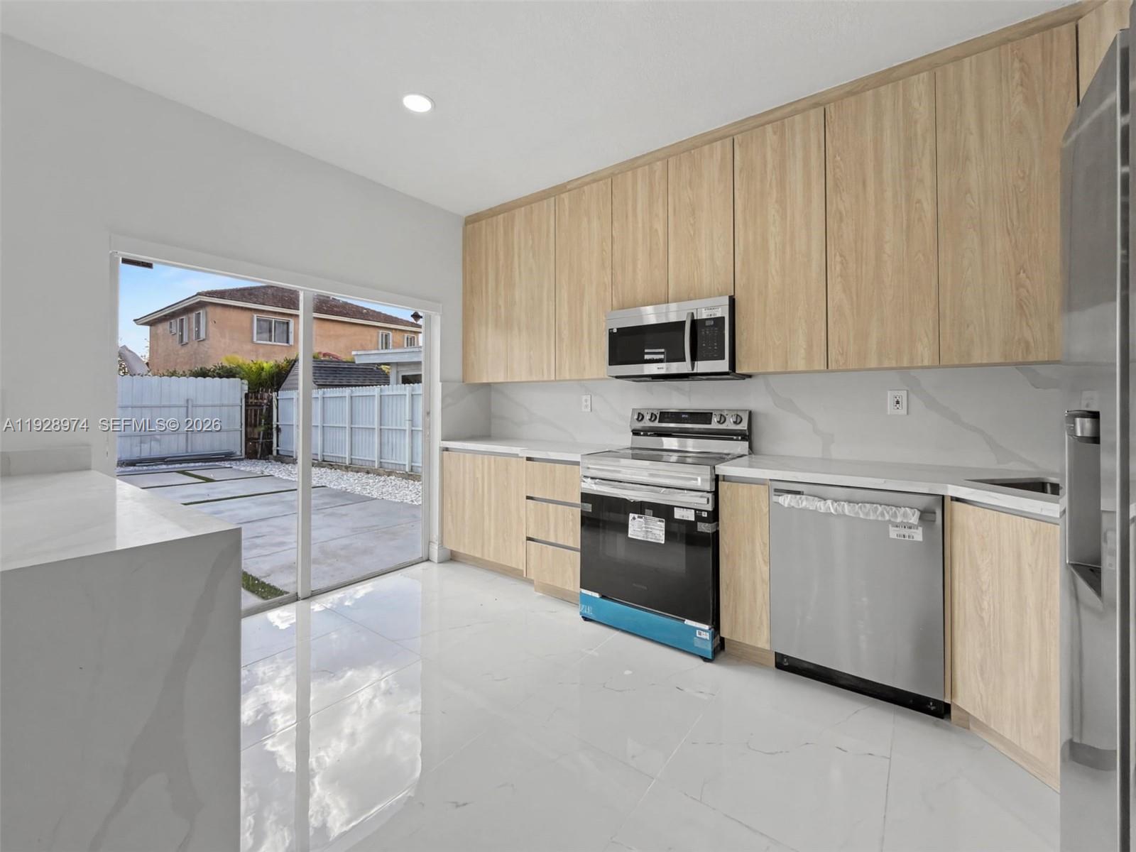 15064 Southwest 30th Terrace Miami, FL 33185 - Photo 7 of 60 a kitchen with stainless steel appliances a stove a sink and a microwave