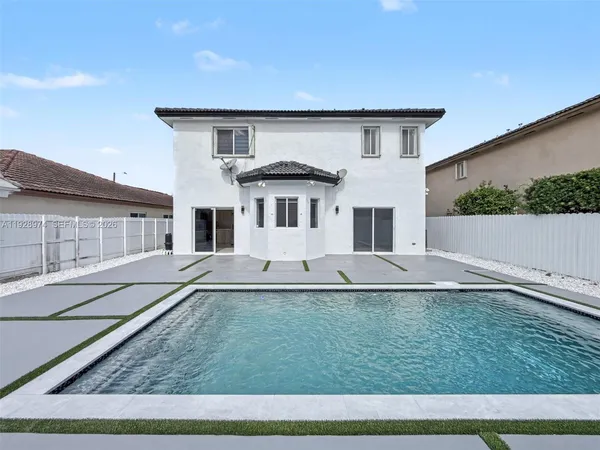 a view of a house with pool and a yard