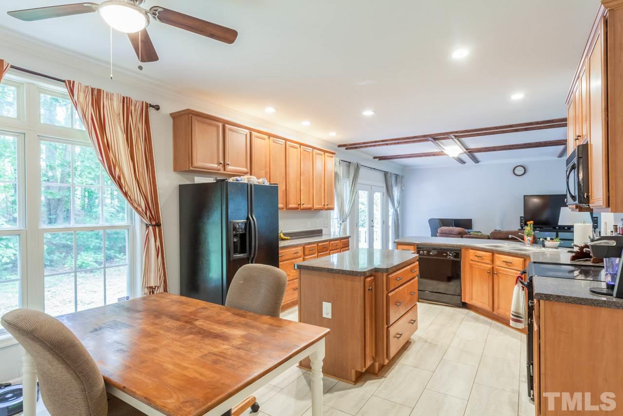 2092 Suitts Store Road Franklinton, NC 27525 - Photo 8 of 21 a kitchen with stainless steel appliances granite countertop a refrigerator a sink dishwasher a stove and a dining table with wooden floor