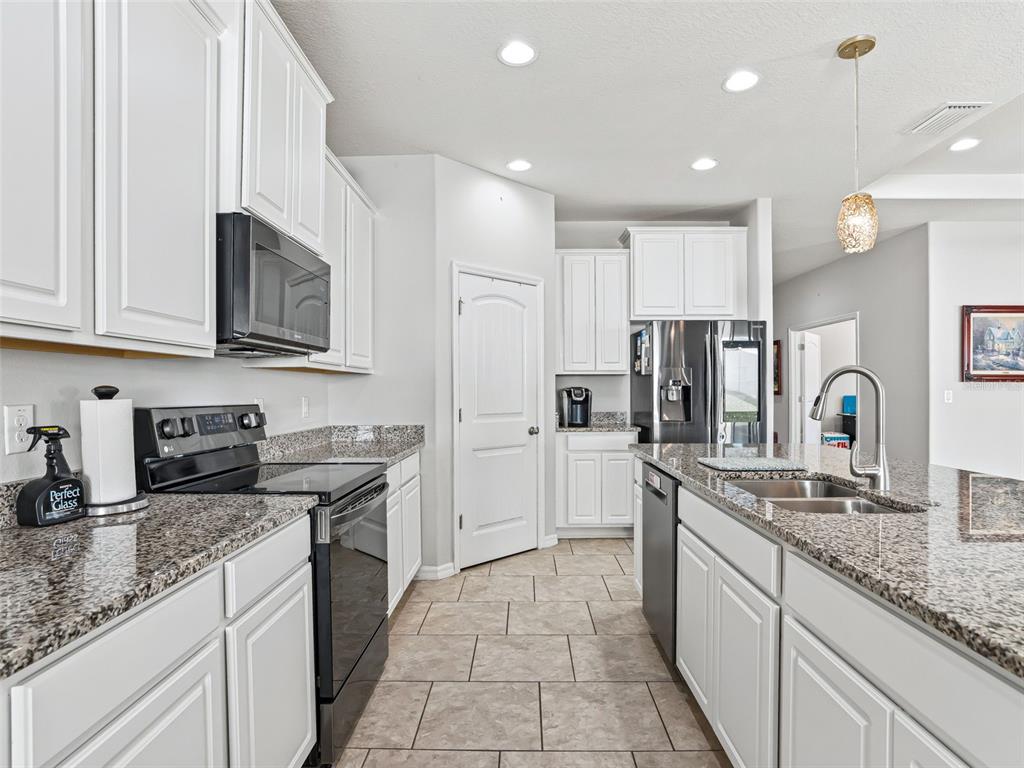 5626 Southwest 50th Court Ocala, FL 34474 - Photo 11 of 33 a kitchen with stainless steel appliances granite countertop a sink stove and refrigerator