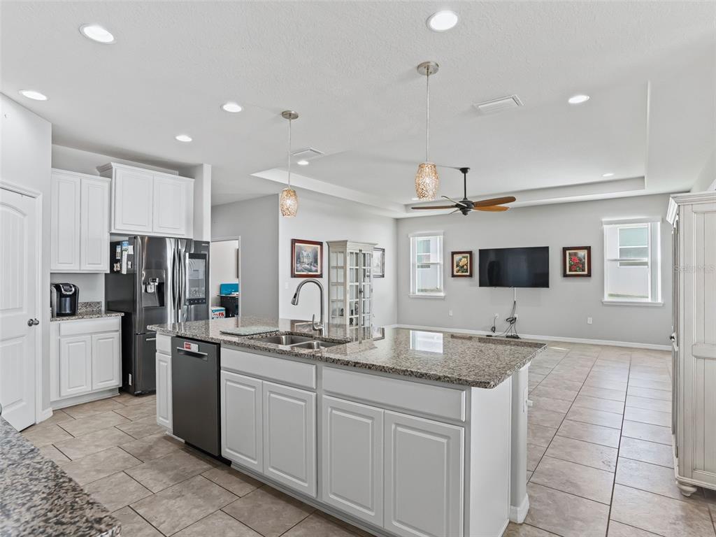 5626 Southwest 50th Court Ocala, FL 34474 - Photo 12 of 33 a kitchen with stainless steel appliances granite countertop a sink refrigerator and cabinets