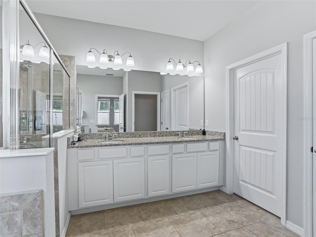 5626 Southwest 50th Court Ocala, FL 34474 - Photo 16 of 33 a bathroom with double vanity and a mirror