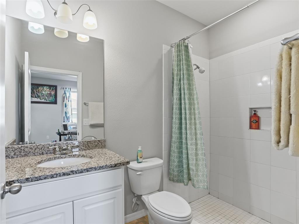 5626 Southwest 50th Court Ocala, FL 34474 - Photo 23 of 33 a bathroom with a granite countertop sink a toilet and a mirror