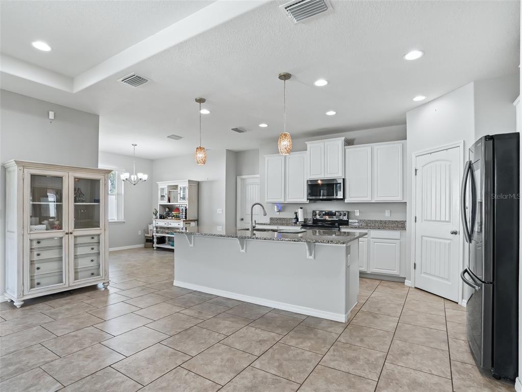 5626 Southwest 50th Court Ocala, FL 34474 - Photo 9 of 33 a kitchen with stainless steel appliances granite countertop a refrigerator and a stove top oven