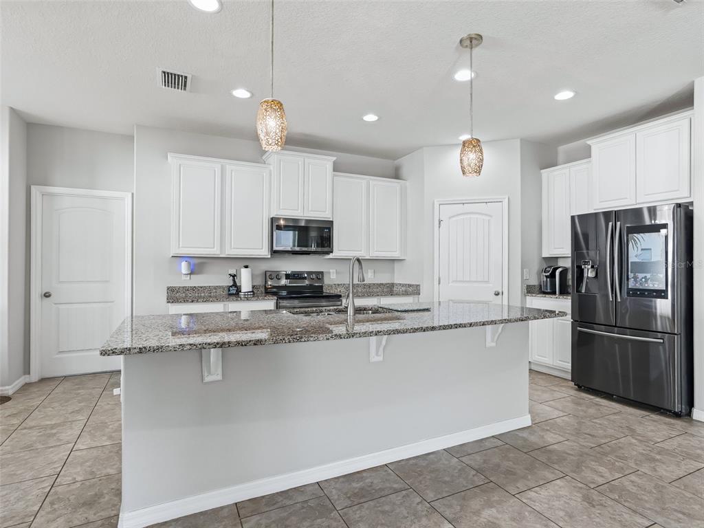 5626 Southwest 50th Court Ocala, FL 34474 - Photo 10 of 33 a kitchen with stainless steel appliances granite countertop a refrigerator a sink and a stove