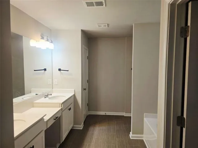 a bathroom with a double vanity sink and mirror