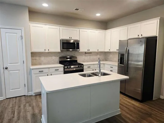 a kitchen with stainless steel appliances a refrigerator stove microwave and sink