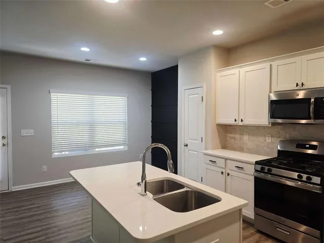 a kitchen with sink a stove and microwave