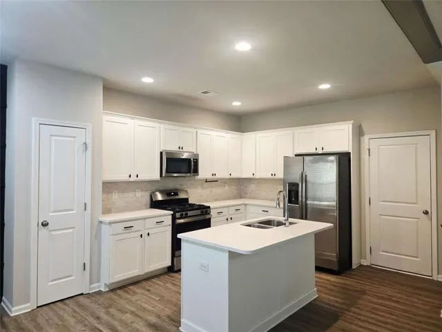 a kitchen with a sink a refrigerator a stove and cabinets