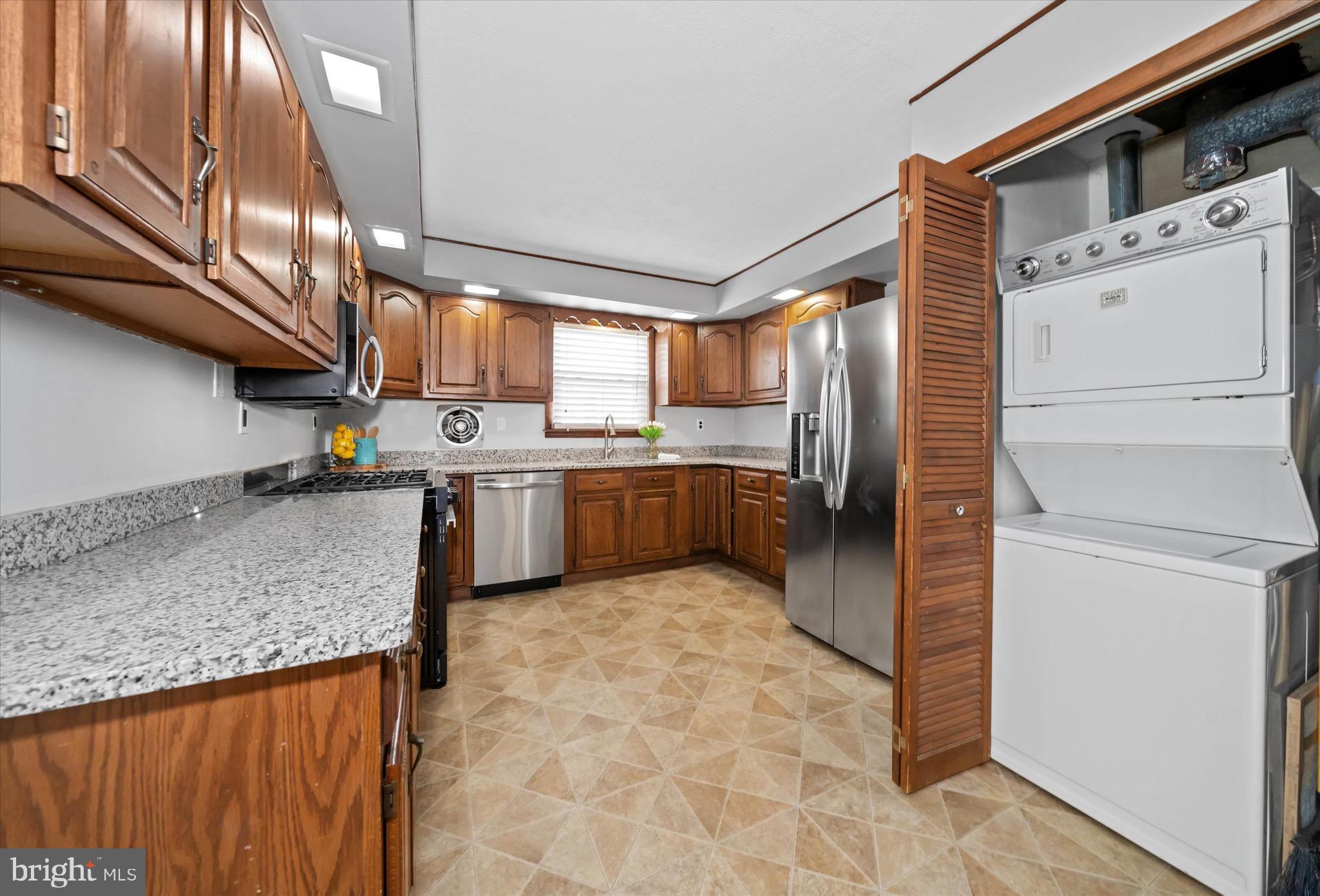 124 Festone Avenue New Castle, DE 19720 - Photo 11 of 43 a kitchen with stainless steel appliances granite countertop a sink stove and refrigerator