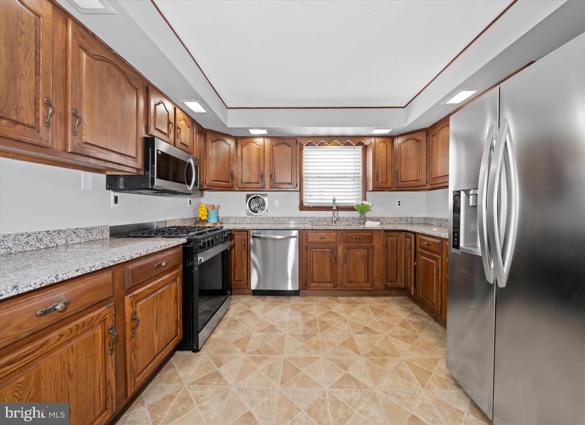 124 Festone Avenue New Castle, DE 19720 - Photo 12 of 43 a kitchen with stainless steel appliances granite countertop a sink a stove a refrigerator cabinets and a window