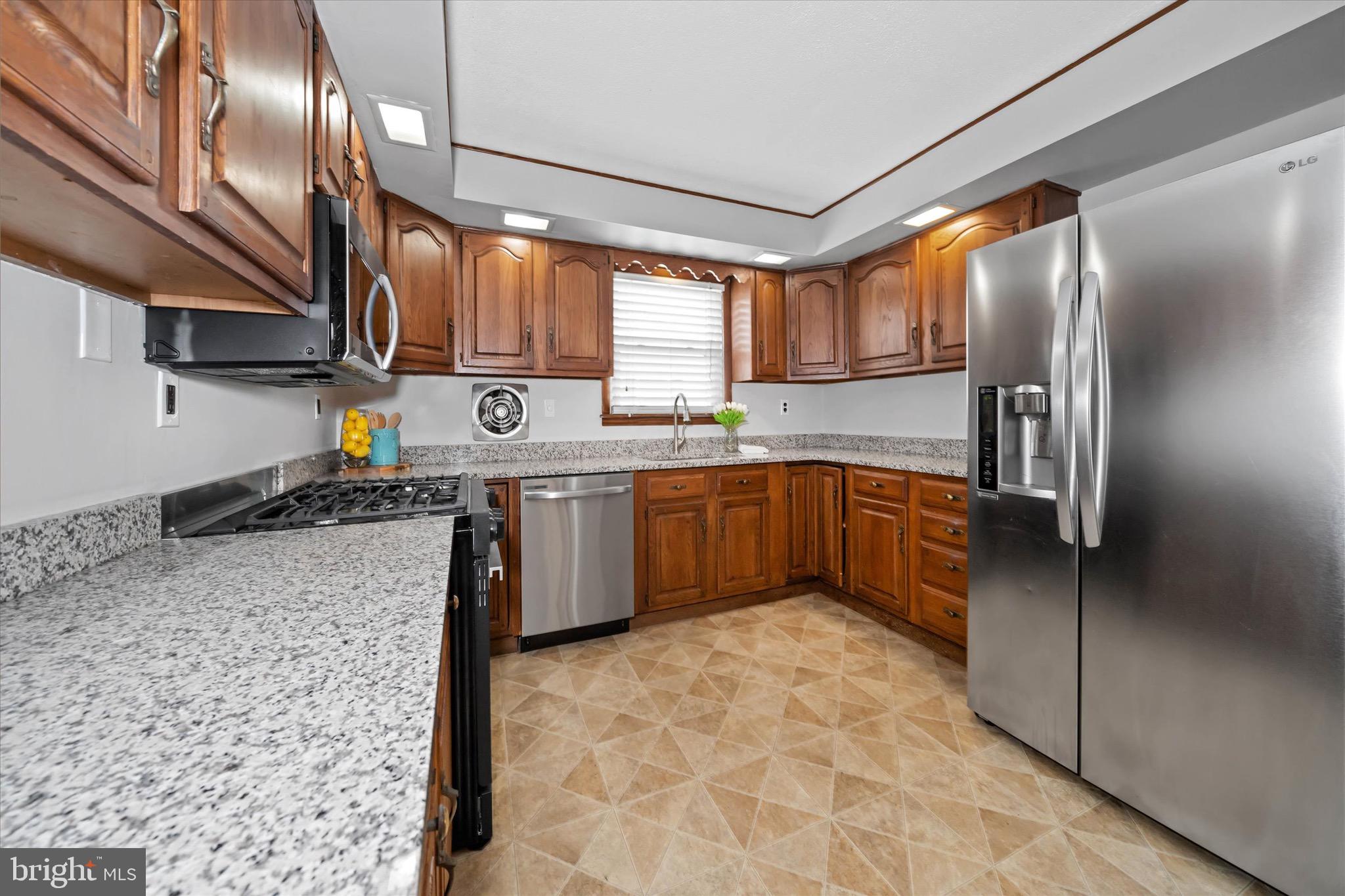 124 Festone Avenue New Castle, DE 19720 - Photo 13 of 43 a kitchen with stainless steel appliances granite countertop a sink a stove and a refrigerator