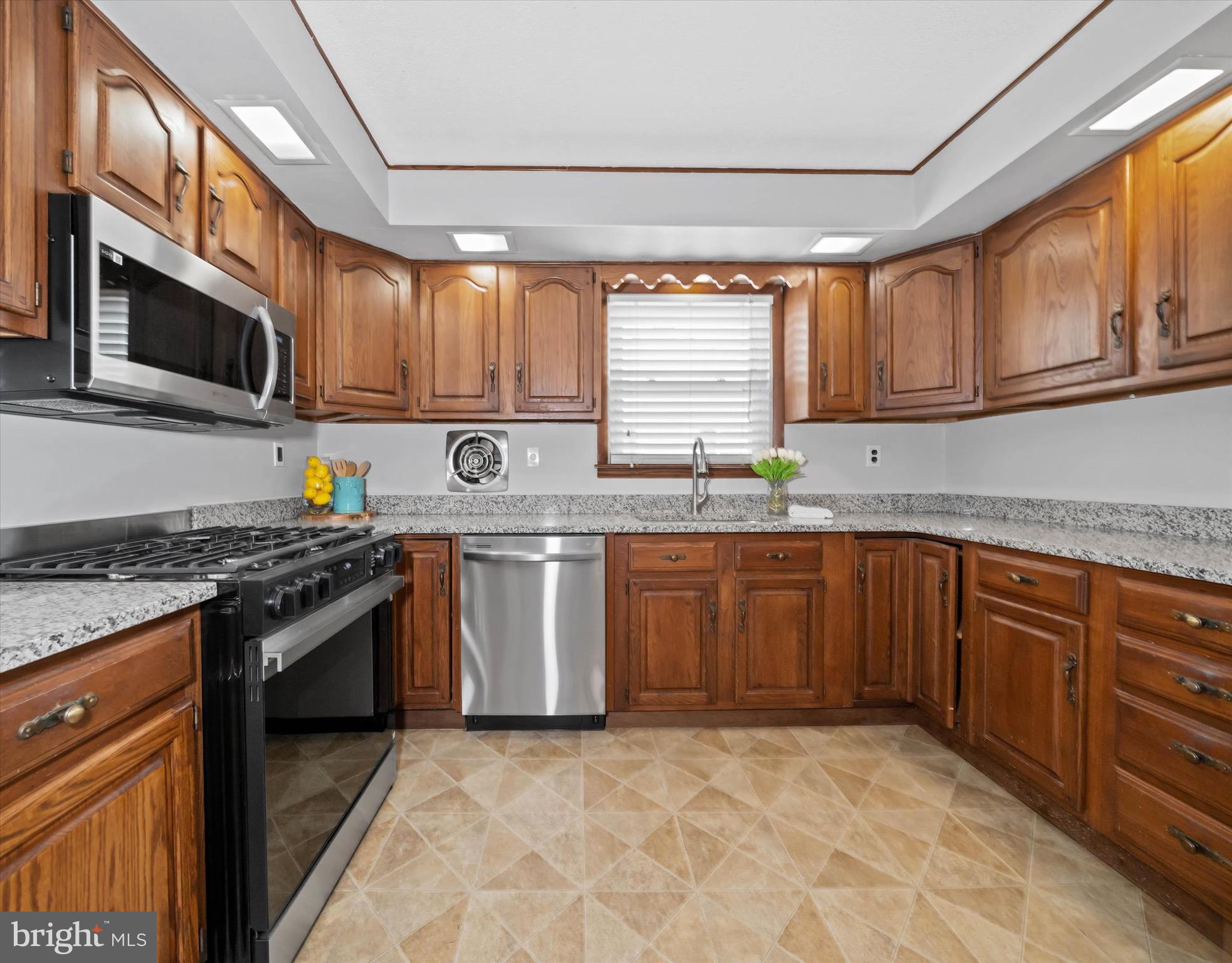 124 Festone Avenue New Castle, DE 19720 - Photo 14 of 43 a kitchen with stainless steel appliances granite countertop a stove sink microwave and window