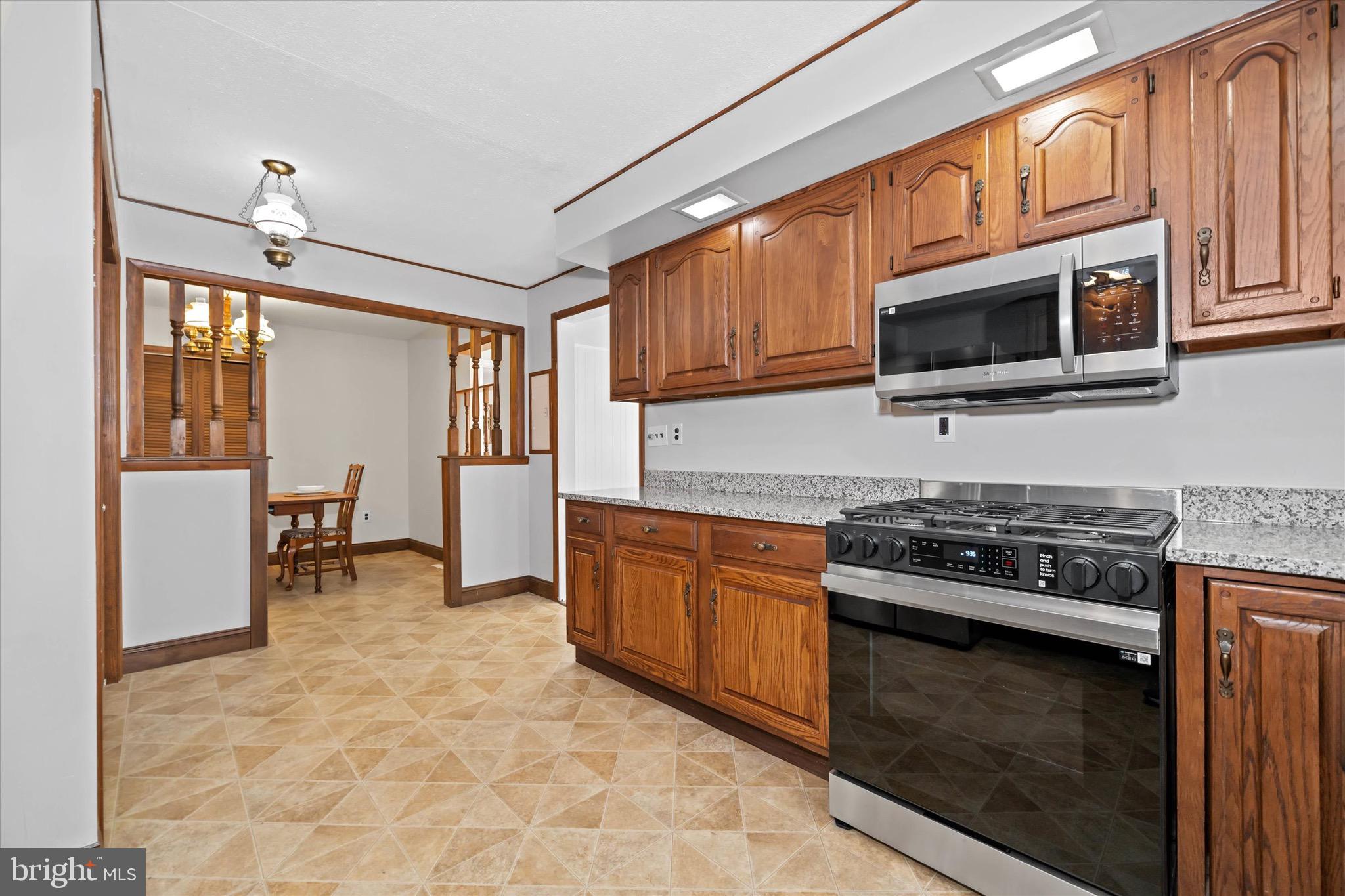 124 Festone Avenue New Castle, DE 19720 - Photo 16 of 43 a kitchen with stainless steel appliances granite countertop a stove microwave and sink