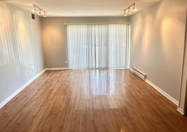 1201 Pleasant Run Drive, Unit 307 Wheeling, IL 60090 - Photo 2 of 7 wooden floor in an empty room with a window