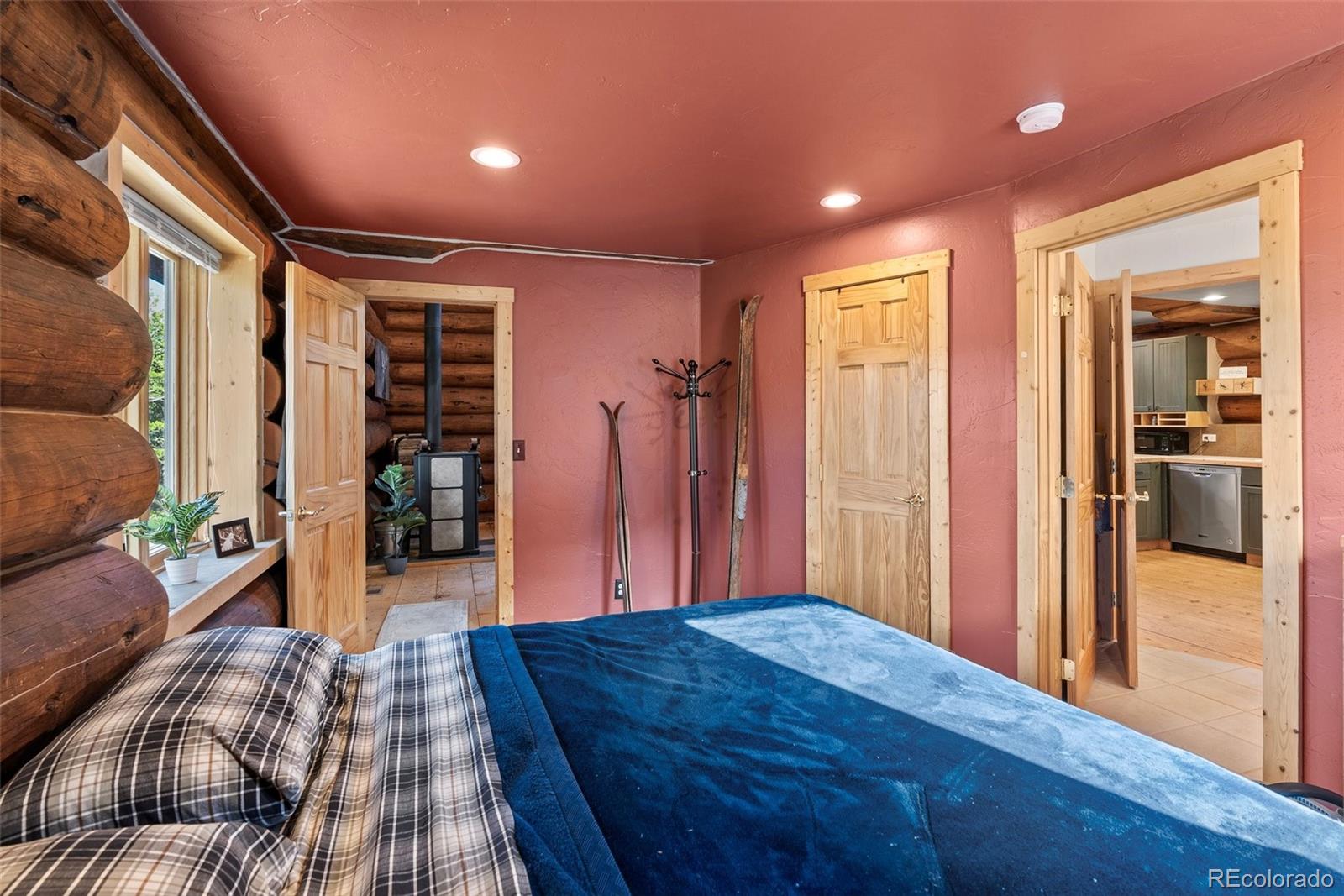 96 Eva Road Idaho Springs, CO 80452 - Photo 19 of 34 a spacious bedroom with a bed and wooden floor