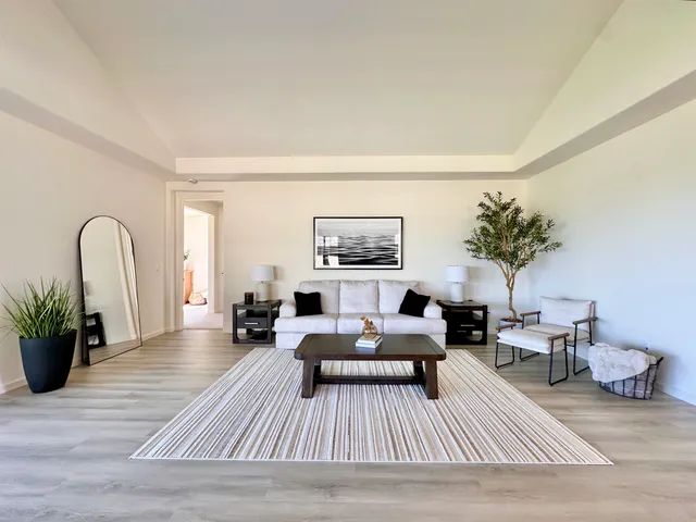 a living room with furniture wooden floor and a table