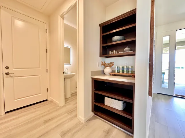 a view of an empty room and wooden floor and kitchen view