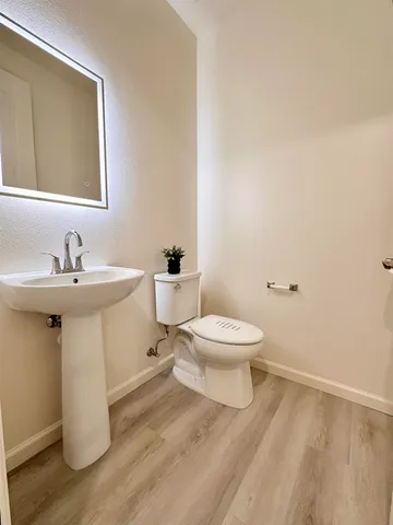 a bathroom with a toilet sink and mirror