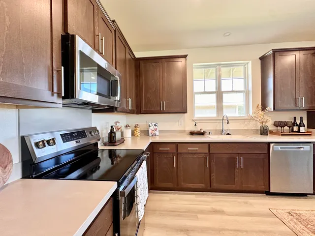 a kitchen with a sink cabinets appliances and a window
