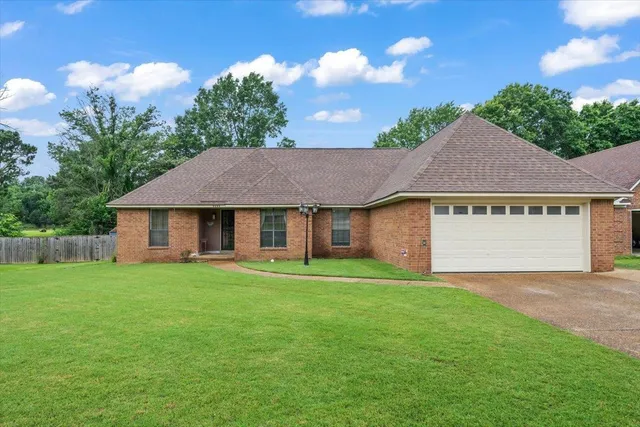 a view of a house with a yard and garage