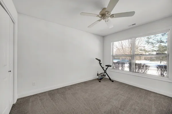a room with a window and a ceiling fan