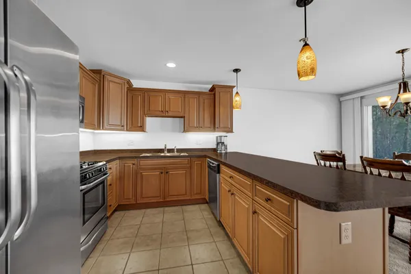 a kitchen with stainless steel appliances granite countertop a sink a stove and refrigerator