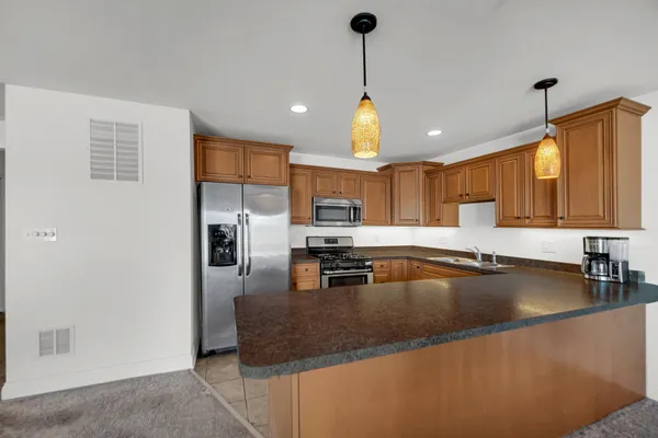 a kitchen with stainless steel appliances granite countertop a sink a stove and a refrigerator