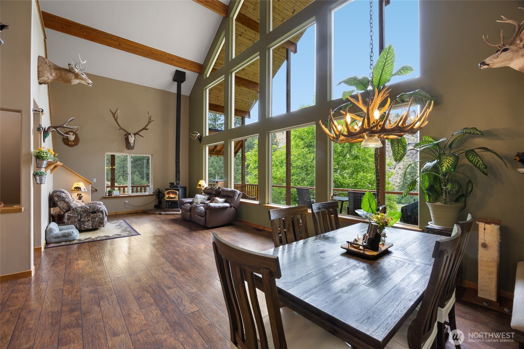 11125 Entiat River Road Entiat, WA 98822 - Photo 13 of 40 a view of a dining room with furniture a potted plant and wooden floor