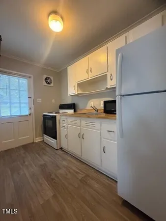a kitchen with white cabinets and white appliances