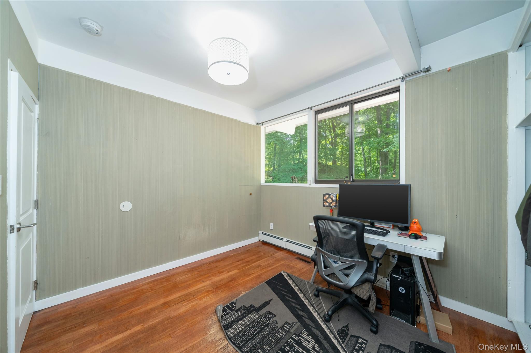 4 Half Mile Road Armonk, NY 10504 - Photo 16 of 28 Bright and inviting third bedroom, currently being used as a home office, with warm hardwood floors, high ceilings, and peaceful natural surroundings.