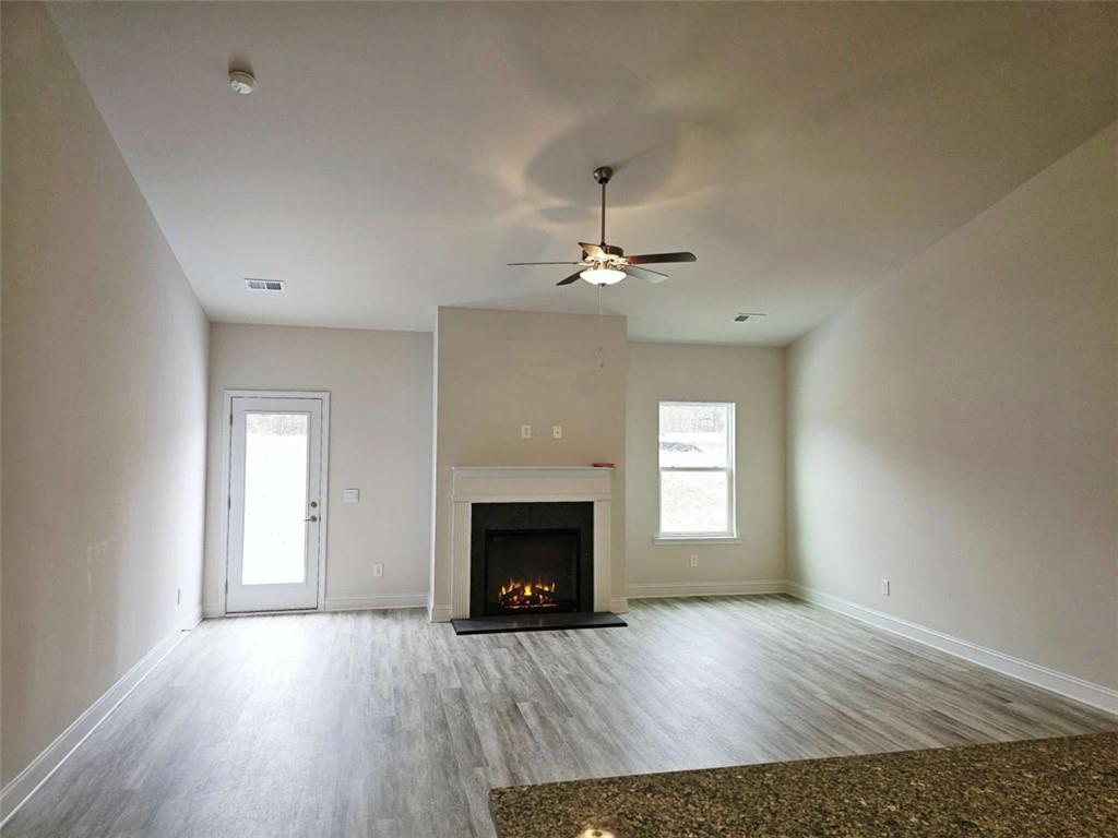 267 Eason Street Bowdon, GA 30108 - Photo 3 of 6 a view of an empty room with wooden floor fireplace and a window