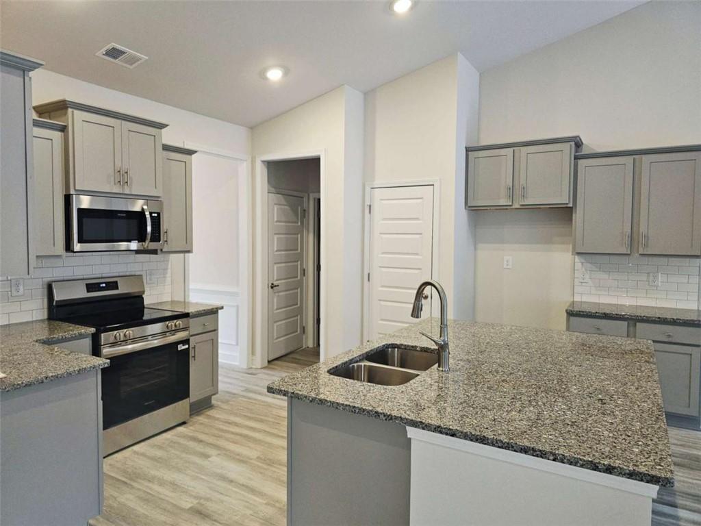267 Eason Street Bowdon, GA 30108 - Photo 4 of 6 a kitchen with granite countertop a sink a stove and refrigerator