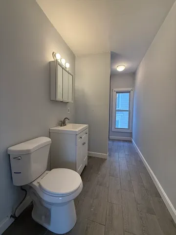 a bathroom with a toilet a sink and mirror