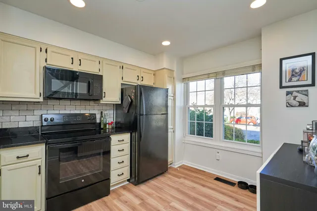 a kitchen with a refrigerator and a stove top oven