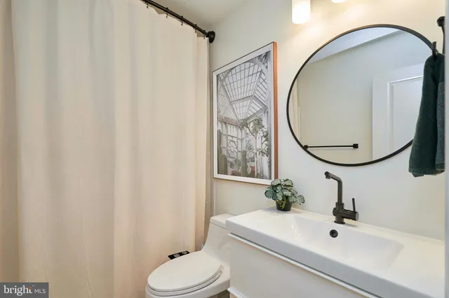 a bathroom with a sink toilet and mirror