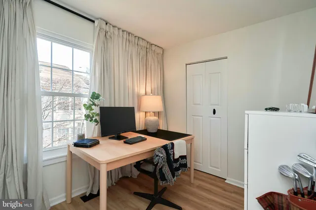 a view of a workspace with furniture and a window