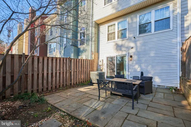a view of a backyard with a large tree and wooden fence