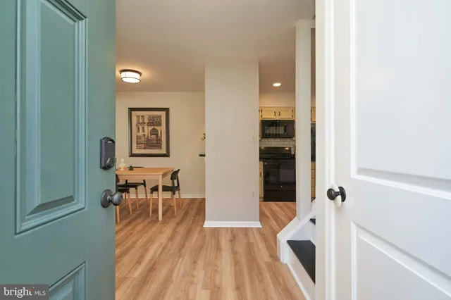 a view of a hallway with wooden floor and dining room