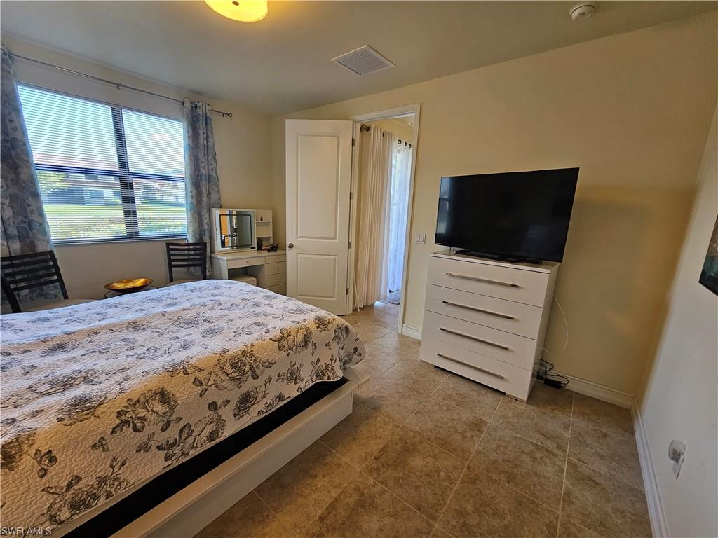 7914 Bristol Circle Naples, FL 34120 - Photo 11 of 22 a bedroom with a bed and a flat screen tv