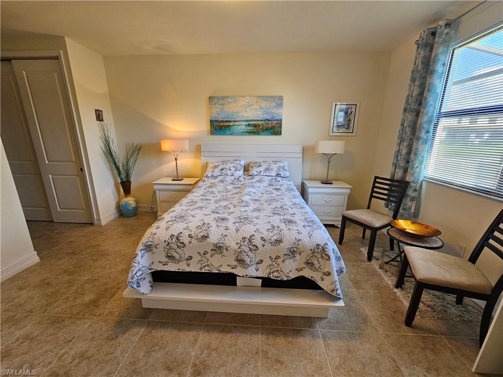 7914 Bristol Circle Naples, FL 34120 - Photo 15 of 22 a bedroom with a bed and a chair