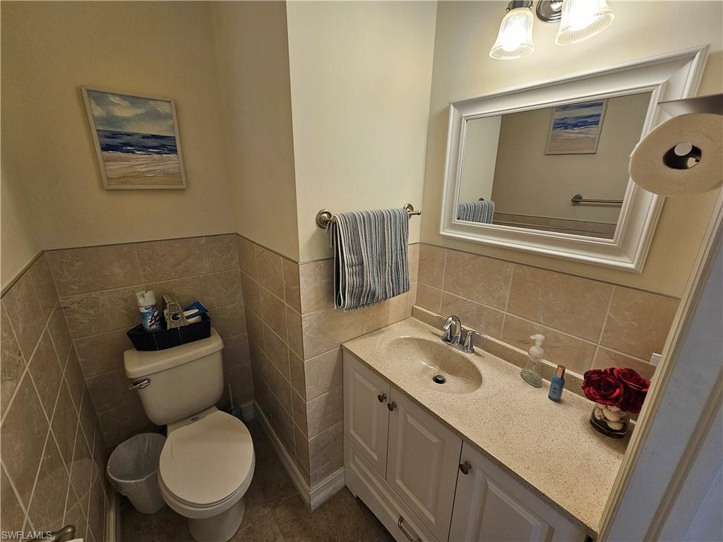 7914 Bristol Circle Naples, FL 34120 - Photo 16 of 22 a bathroom with a toilet sink vanity and mirror