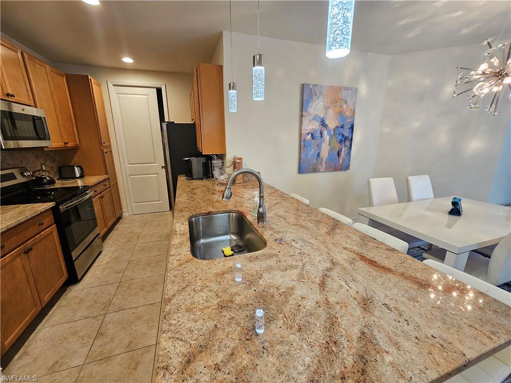 7914 Bristol Circle Naples, FL 34120 - Photo 6 of 22 a kitchen with stainless steel appliances a stove a sink a refrigerator and microwave