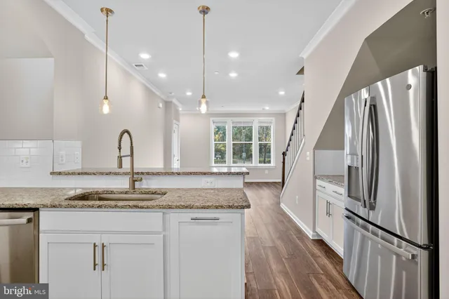 a view of a kitchen with wooden floor and electronic appliances