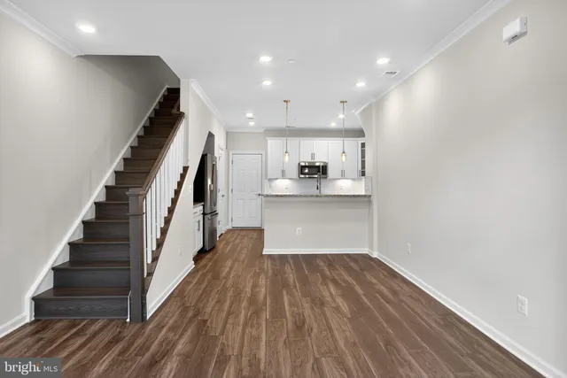 a view of kitchen with kitchen island granite countertop cabinets and refrigerator