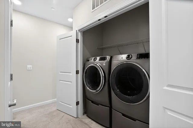 a view of a house with a barbeque and large trees