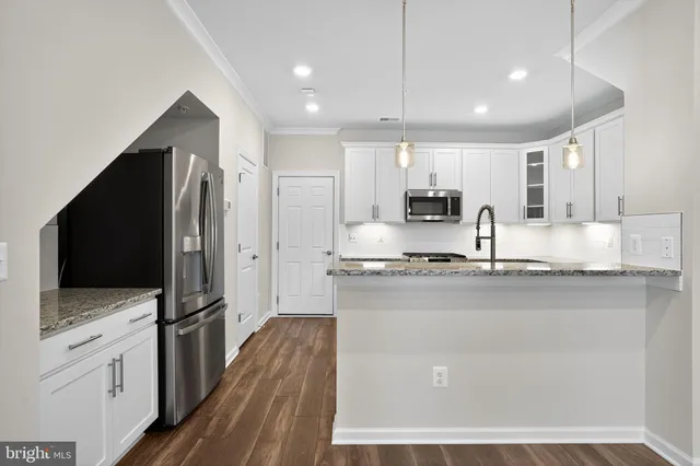 a kitchen with stainless steel appliances granite countertop a refrigerator and a stove