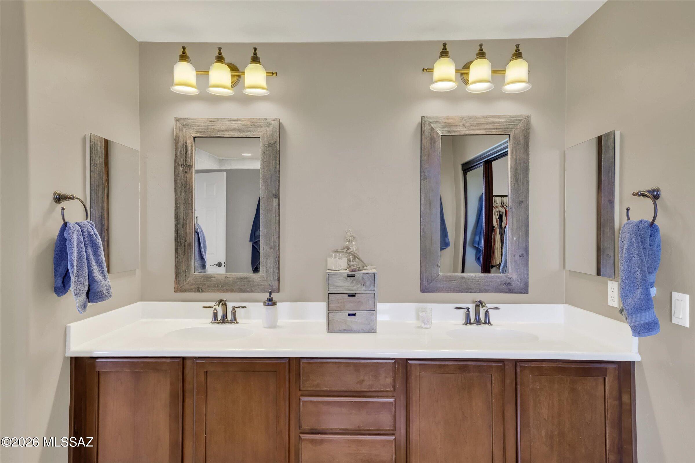 6095 South Jakemp Trail Tucson, AZ 85747 - Photo 28 of 52 a bathroom with double vanity sinks and a mirror