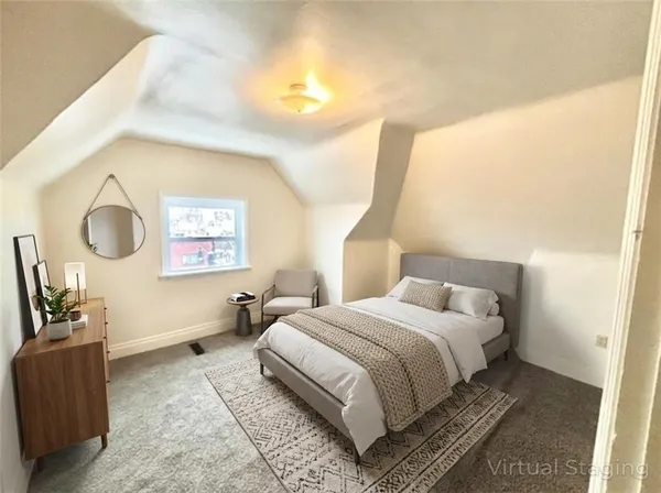 a bedroom with a bed and dresser with mirror